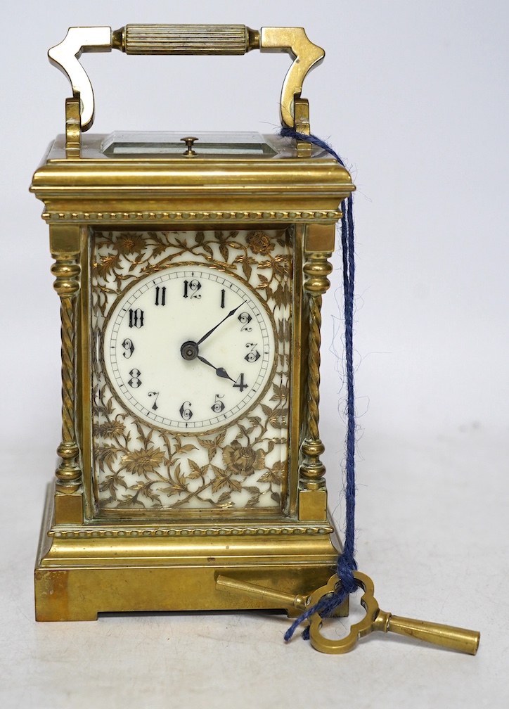 A large brass repeating carriage clock with key and ornate filigree dial, 17cm high (including handle). Condition - good, unchecked if working